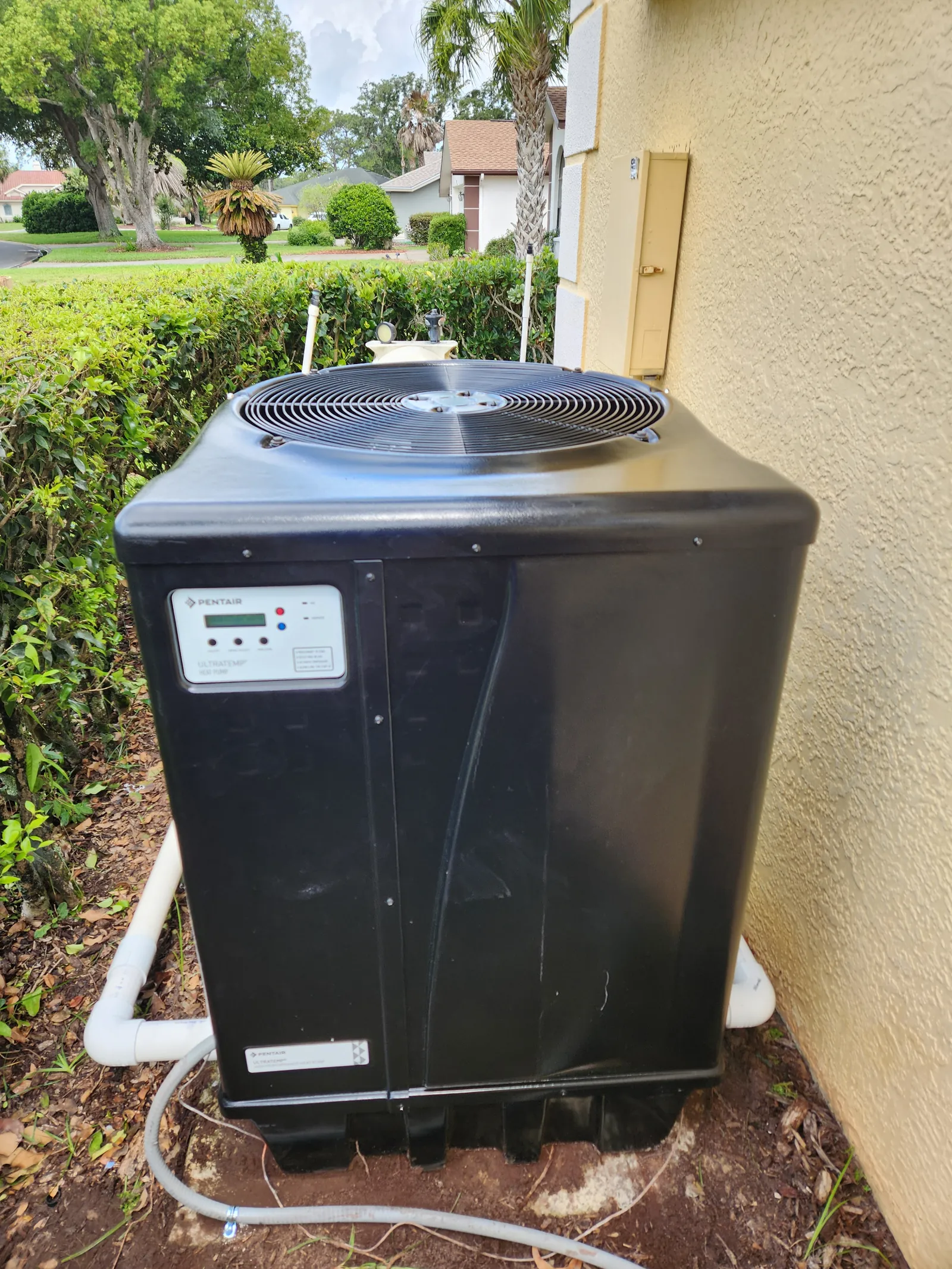 New Pentair UltraTemp heat pump installed beside a home in Weeki Wachee, FL