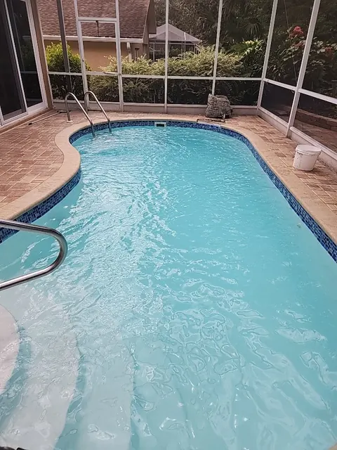 Clean kidney-shaped pool in a screened lanai in Timber Pines, Spring Hill